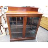 A Victorian mahogany twin door glazed bookcase having a raised top, 49"h x 42"w