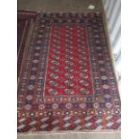 A Bokhara red ground rug having multiguard borders with geometric designs, 79" x 47"