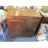 A 19th century mahogany cabinet with a hinged top over a pair of doors