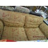 A three piece suite upholstered in a red and gold tapestry style fabric, comprising a sofa and a