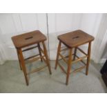 A pair of mahogany and beech laboratory stools