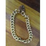A 9ct gold hollow curb link bracelet with heart shaped catch, 16.4g