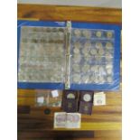 A folder containing various British commemorative coins and coinage to include a half crown 1900,