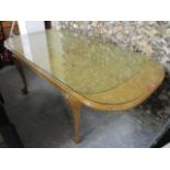 A mid 20th century burr walnut veneered, extending dining table, standing on ball and claw feet,