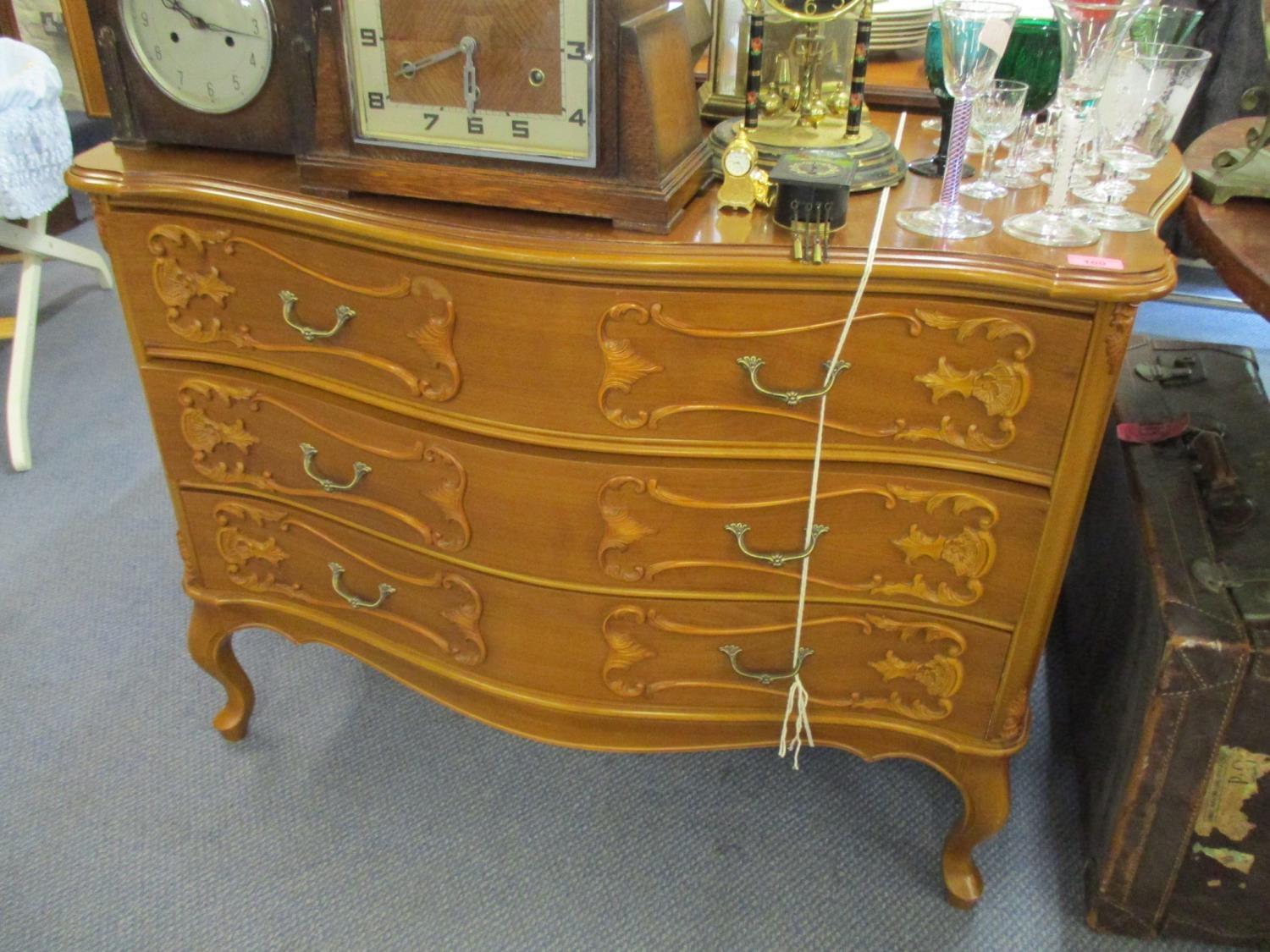 A reproduction yew serpentine fronted French style chest with three long drawers