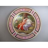 A late 19th century plate painted with two women embracing under a tree with bows and arrows by them