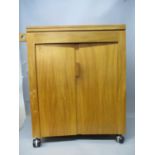 A Jack Christmas sycamore sewing machine cabinet with an inlaid, hinged top, over two doors on