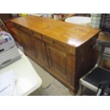 A large modern cherrywood sideboard having three drawers above three cupboard doors 39"h x 74"w