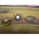A 9ct gold opal and garnet ring, a yellow metal and white stone full eternity ring and a 9ct gold