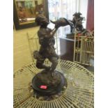 A bronzed composition figurine of a man throwing a cornucopia horn, on an ebonized base A/F