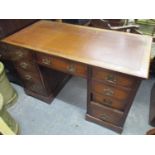 An early 20th century oak twin pedestal desk having a leather topped scriber, one long central