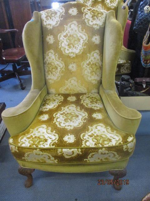 A reproduction Georgian style wing back chair with scrolled arms, carved, cabriole front legs with