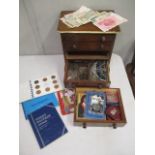 A stained pine four drawer chest containing various coins sets, banknotes, foreign coins and