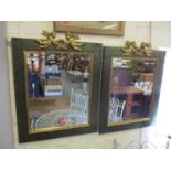 A pair of mottled green and gilt framed mirrors with cherub ornament