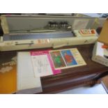 A Toyota knitting machine with a lace carriage, and punched pattern cards and pattern books