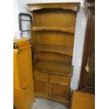 A reproduction cherry finished bookcase having display shelves above two short drawers and two