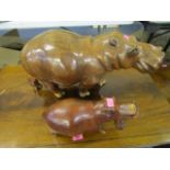 A large African carved wooden model of a hippo and a similar smaller hippo