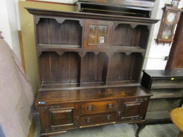 An early 20th century oak dresser, the top with central glazed display door over open shelves with