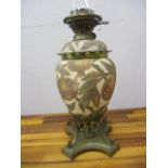 A late Victorian brass and ceramic oil lamp decorated with poppies and leaves