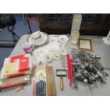 A mixed lot to include stainless steel cutlery, magnifying lens, placemats and other items, along