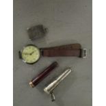 A silver cased wristwatch on a brown leather strap, a silver cheroot holder case, a cheroot holder