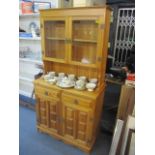 A modern pine display dresser having twin glazed doors above drawers and cupboard doors