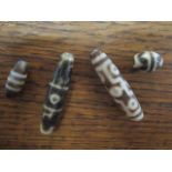 A group of four Tibetan carved agate loose beads, late 20th/early 21st century