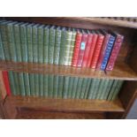 A collection of late 20th century editions of Charles Dickens and other novels, in green and red