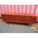 A mid 20th century exotic wood sideboard with sliding doors on tapered legs 30"h x 84"w