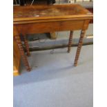 A 19th century walnut card table with a rotating, fold over top on bobbin turned legs