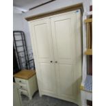 A cream painted and light wood double wardrobe with matching bedside chest of three drawers