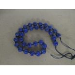 A Chinese carved lapis lazuli beaded necklace