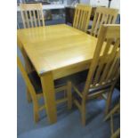 A modern oak extending dining table with two additional leaves on square legs and a matching set