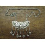 A contemporary Chinese white metal plaque necklace with pierced lion dog and pearl decoration,