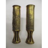 A pair of 1915 Great War trench art artillery shells with pinched bases, embossed with a bunch of