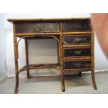 A late 19th century lacquered and bamboo desk with a tooled gilt, red leather scriber and floral