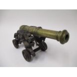 A late 19th/early 20th century model cannon, with a bronze barrel and cast iron sides fashioned as