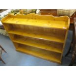 A modern pine four tier bookcase, standing on a plinth base, 41" h x 49"w