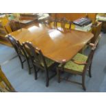 A reproduction mahogany extending dining table, together with a set of ten Hepplewhite style chairs