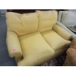 A beige upholstered two seater sofa