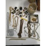 A mixed lot of gold coloured chain necklaces, silver charms, thimbles and various costume jewellery