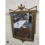 An Edwardian gilt gesso wall mirror, rectangular bevelled glass surmounted by an urn and husk swaged