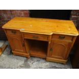 A Victorian pine sideboard having three drawers, two cupboards, standing on bun shaped feet 30 1/2"h