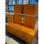 A mid 20th century light oak bedroom suite consisting of two wardrobes, a dressing table and a chest