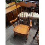 A mid 20th century beech spindle back rocking chair