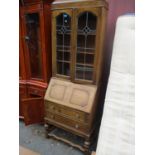 A 1920s oak bureau bookcase having fall flap above two drawers 78 1/2"h x 29"w, together with a