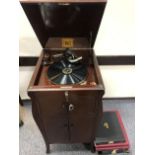 An HMV mahogany free-standing gramophone, together with eight folders of 78 records