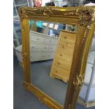 A modern gilt framed mirror with leaf decoration