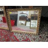 A square shaped wall mirror with scrolled leaf, gilt frame