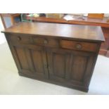 An early 20th century oak sideboard having three inset drawers and twin cupboards below 39"h x 55"w